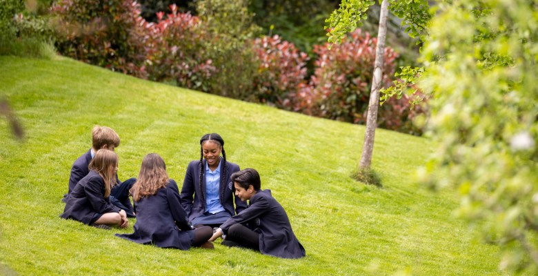 Senior pupils sitting in the garden and talking at Ibstock Place School
